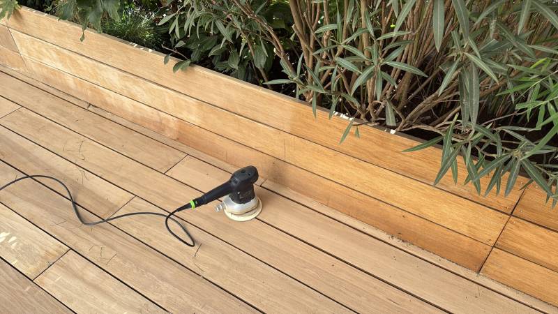 Ponçage précis d'une terrasse en bois exotique