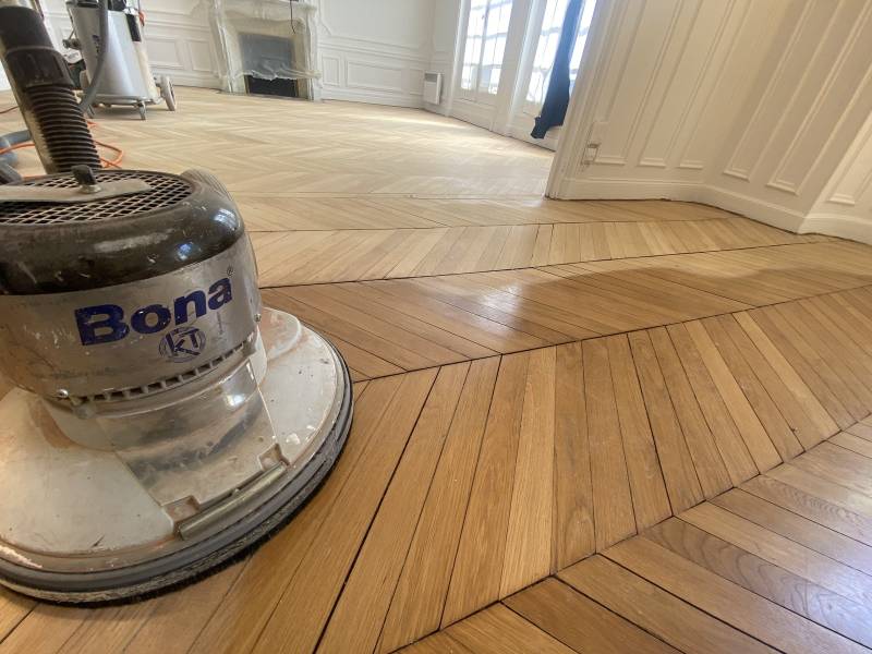 Ponçage en cours de ce parquet massif en chêne Pointe de Hongrie à Versailles dans les Yvelines à l'aide d'une ponceuse Monobrosse Bona